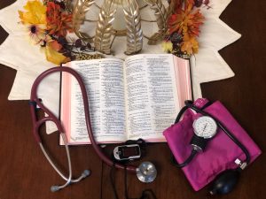 opened bible with stethoscope and blood pressure tool on top